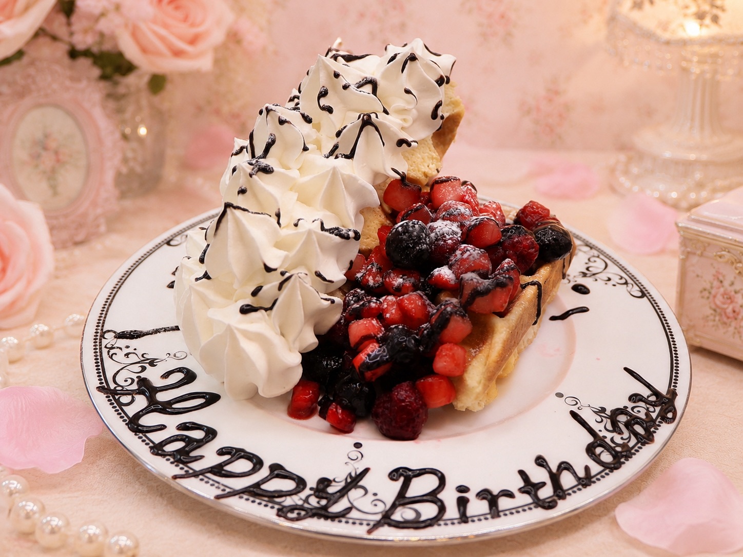 花に囲まれたテーブルに置かれた誕生日デザート